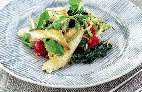Ensalada templada de caballa con brotes frescos y rabanitos Una colorida ensalada de caballa servida en un plato con un delicado patrón de rayas grises. El plato combina filetes de caballa dorados con una mezcla de brotes verdes, hojas de espinaca y rabanitos rojos cortados por la mitad, creando una presentación fresca y equilibrada que resalta los ingredientes naturales.