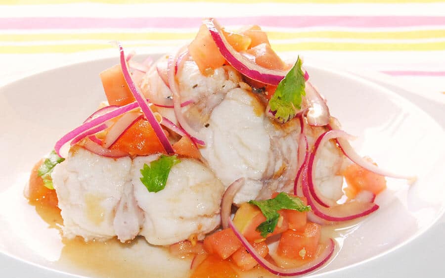 Tacos de rape cocido servidos con una vinagreta fresca de tomate natural y cebolla roja laminada.