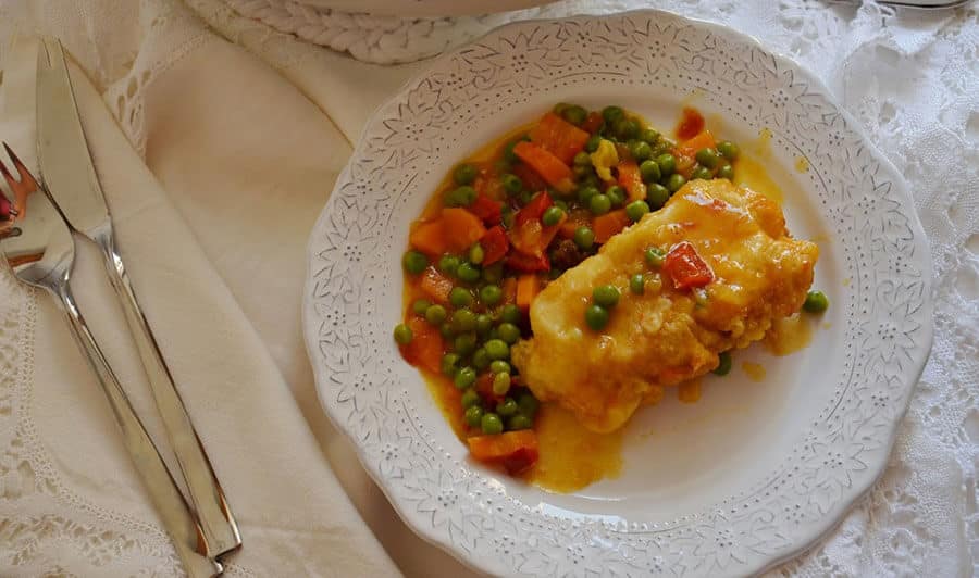 Lomo de rape preparado al estilo Cedeira, acompañado de una guarnición de guisantes, zanahoria y pimientos en una salsa ligera.